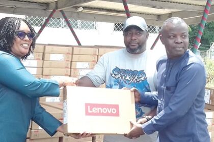 Rita Akosua Adjei Awatey (left), Eastern Regional Minister, presenting one of the laptops to Francis Addo Akumatey, Municipal Chief Executive for Yilo Krobo in Koforidua