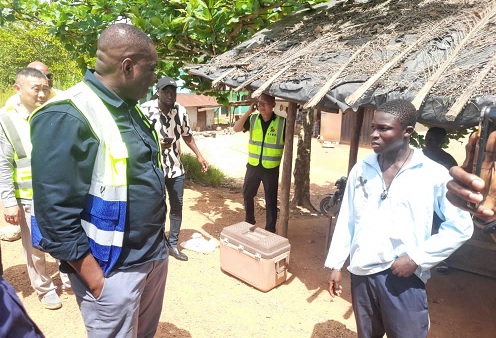 Governs Agbodza (left), Minister of Roads and Highways, interacting with some community members at Nsuano, along the Elubo-Enchi road